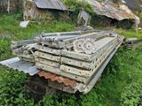 an old wooden bench in the middle of a field with a house in the background
