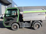 a green and black truck parked in a parking lot