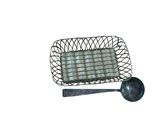a small metal basket with a spoon and spoon rest on it