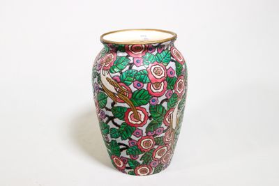 un vase avec un motif floral sur une surface blanche