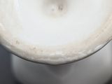 a close up of a white vase on a table