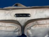 an image of a white purse on a blue surface