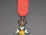 an image of a medal with a red ribbon on a black surface