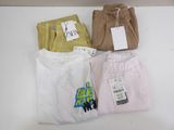 three pairs of men ' s pants and a t - shirt are on a table