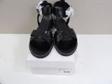 pair of black sandals on a white box on a white surface