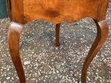 an old wooden table with a small drawer on top of it