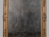 an image of a mirror with a gold frame on a gray wall