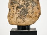 an image of a stone head on a black stand
