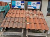 roof tiles are stacked on top of each other in front of a building