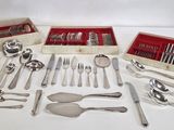 beaucoup d'argenterie sur une table où se trouve une boîte rouge
