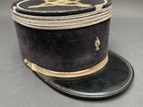 un vieux chapeau noir orné d'un ruban doré sur le dessus