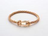 un bracelet en or en forme de corde avec un fermoir, sur fond blanc