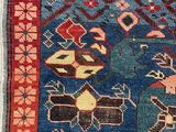 an image of a blue and red rug with a cat on top of it