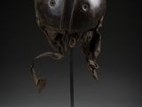 an old helmet on a metal stand with a black background