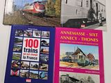 three books on a table with pictures of trains on them