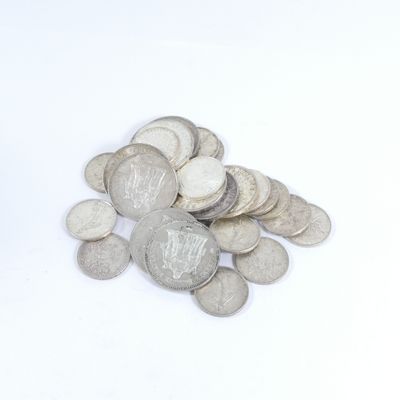 une pile de pièces d'argent posée sur une surface blanche