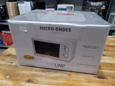 emballage d'un micro-ondes posé sur une table en bois dans un magasin
