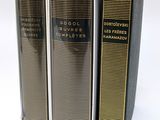 three books sitting on top of each other on a white surface