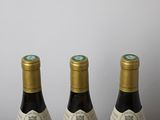 three bottles of wine sitting on top of a table next to each other