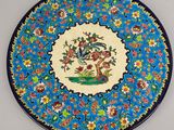 an image of a decorative plate with a bird and flowers on it