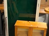 two wooden cabinets and a glass door in a room