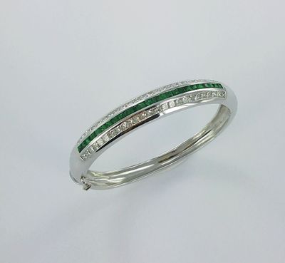 une bague en or blanc sertie d'une émeraude et de diamants