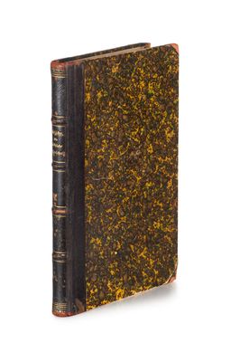 un vieux livre à la couverture noire parsemée de touches dorées