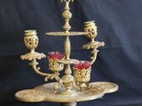 an antique brass candelab with three candles on a stand