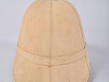 beige leather helmet on a white surface with a white background