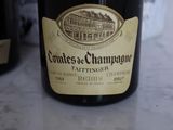 a bottle of champagne sitting on a table next to a bottle of wine