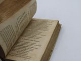 a person holding an open book on a table