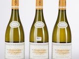 trois bouteilles de vin blanc posées les unes à côté des autres sur une table
