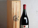 une bouteille de vin posée sur une table à côté d'une caisse en bois