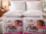 two pillows on the bed with a picture of a woman on it
