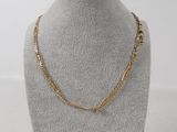 a gold chain necklace on a mannequin display with a white background