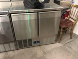 a trash bag sitting on top of a stainless steel refrigerator