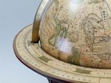 a globe on a stand with a map on top of it