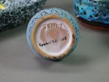 a close up of a vase on a table with other vases in the background