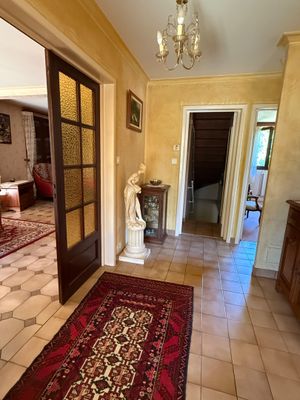 a hallway with a red rug and a chandelier