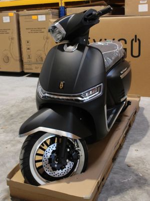 un scooter posé sur un chariot dans un entrepôt