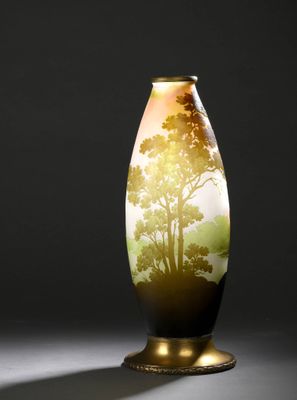 un gros plan d'un vase orné d'un arbre, posé sur une table