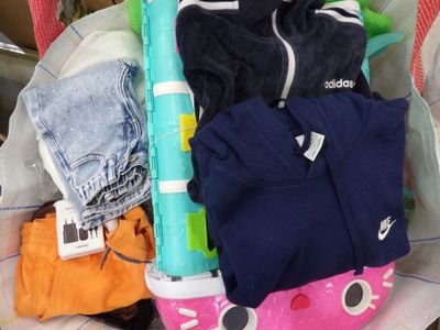 une valise remplie de vêtements et un téléphone portable