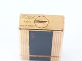 a small gold box with a black label on it