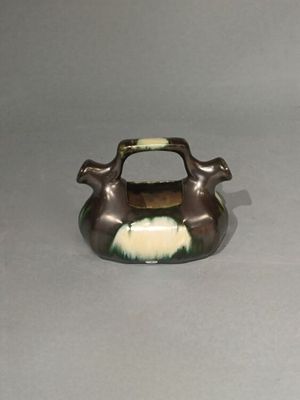 un vase marron et blanc muni d'une anse