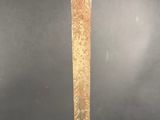 a close up of a sword with a wooden handle on a black background