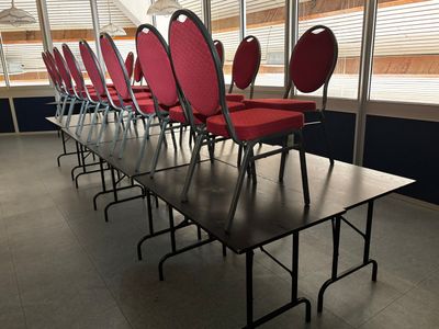 de nombreuses chaises rouges alignées en rang dans une pièce