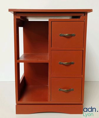une armoire orange surmontée de trois tiroirs
