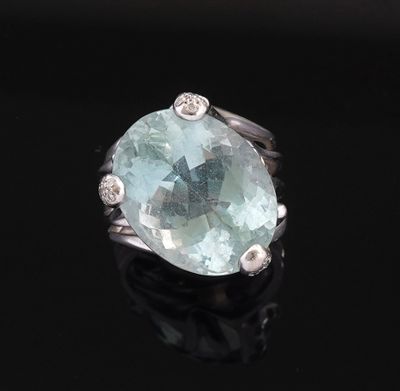 an oval aquamarinee and diamond ring on a black surface