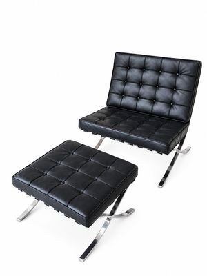 fauteuil et repose-pieds en cuir noir sur fond blanc