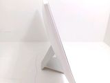 a white computer monitor sitting on top of a white table